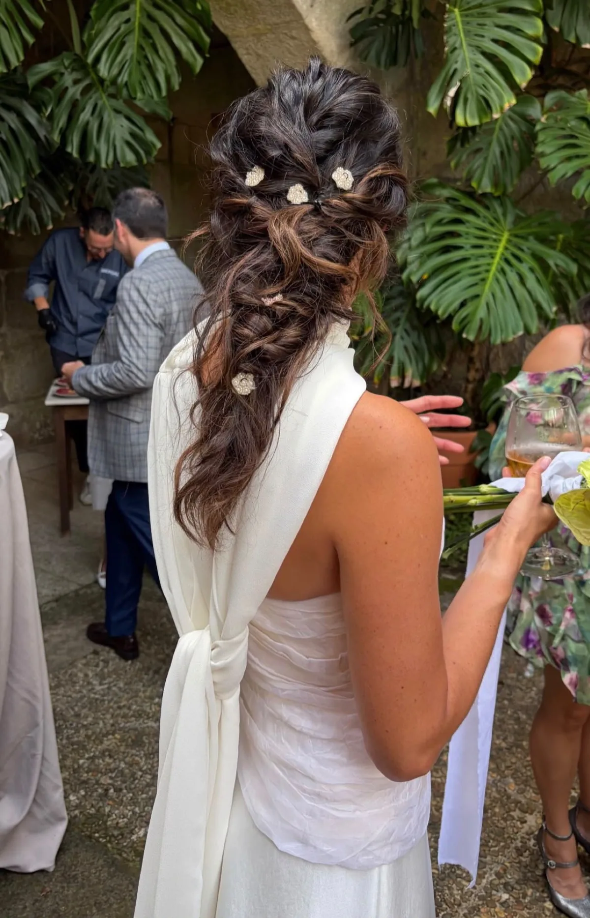 Semirrecogido con ondas y flores blancas de Sabela Abreu visto de espaldas