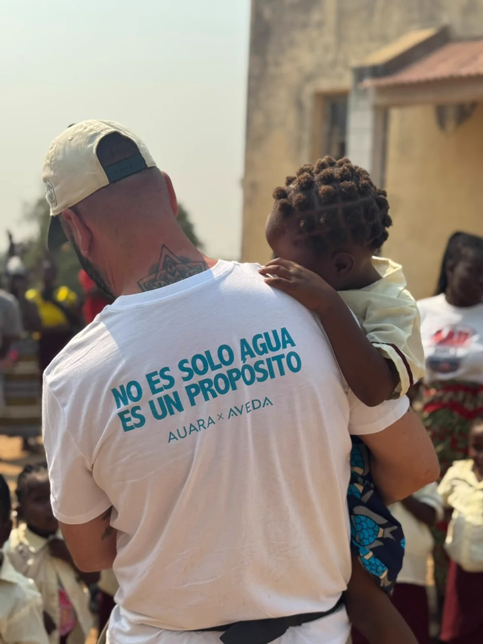 Una persona del proyecto AUARA y Aveda sostiene a una niña en Mozambique