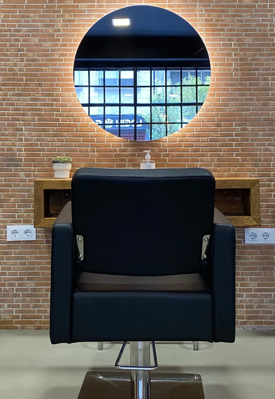 Puesto de trabajo de La Urbana con sillón y espejo circular retroiluminado